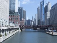 a large boat traveling down the river next to a big city skyline during the day