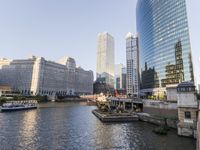 a large boat traveling down the river next to a big city skyline during the day