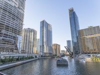 a large boat traveling down the river next to a big city skyline during the day