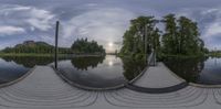 this is the 360 - time view of a boathouse on a river, with the sun behind a sky line