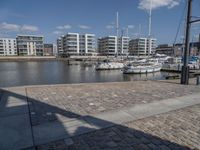 some boats are docked next to a riverbank and buildings in the background while sun shines on them