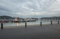 several boats are anchored at the marina with traffic cones along side of the river water