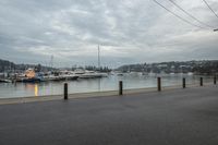 several boats are anchored at the marina with traffic cones along side of the river water