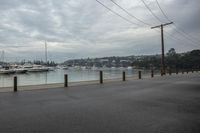 several boats are anchored at the marina with traffic cones along side of the river water