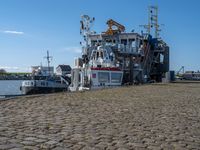 a tugboat sits at a dock with other boats nearby in the harbor area by a body of water