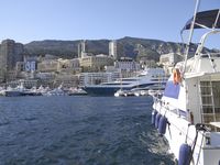 white boats in the water surrounded by a city area and mountains on a clear day