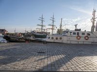 several boats docked in a marina with sails tied to them and flags of countries around them