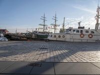 several boats docked in a marina with sails tied to them and flags of countries around them