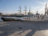 several boats docked in a marina with sails tied to them and flags of countries around them