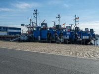 a couple of boats docked near a dock with other ships in the water behind them