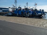 a couple of boats docked near a dock with other ships in the water behind them