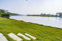 the grassy area is filled with stairs and boats in the water near trees and grass