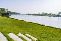 the grassy area is filled with stairs and boats in the water near trees and grass