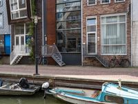 two boats are moored to the shore with some stairs up next to them and bicycles parked beside them