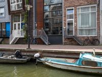 two boats are moored to the shore with some stairs up next to them and bicycles parked beside them