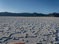 the hand is reaching up to touch a salt flat field that has been created by salt tracks