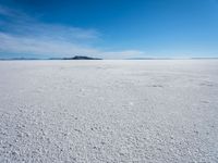 the salt has no clouds and a very small hill on it in the distance is a lake