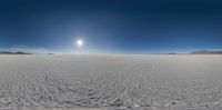 a view from a fish - eye lens looking up at the sky over an icy desert