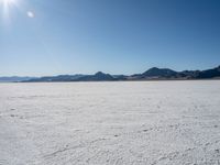 there is a person riding skis on the ice covered ground of the desert in the sun