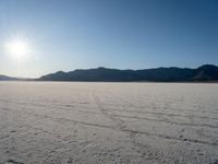 there is snow covering the surface of the flat ground on the horizon at sunrise time