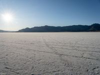 there is snow covering the surface of the flat ground on the horizon at sunrise time