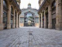 an outdoor market area with old stone flooring and an ornate clock tower on the building