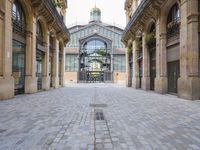 an outdoor market area with old stone flooring and an ornate clock tower on the building