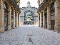 an outdoor market area with old stone flooring and an ornate clock tower on the building