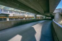 the bottom of an overpass in an underpass next to other structures and cars