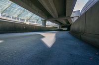 the bottom of an overpass in an underpass next to other structures and cars