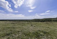 the landscape looks out over the open space on the horizon of land and clouds above it