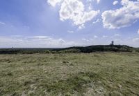 the landscape looks out over the open space on the horizon of land and clouds above it