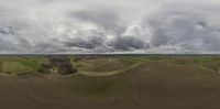 a fisheye view of an aerial scene showing dirt fields, and trees in the middle of the landscape