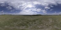 a wide shot from a fish - eye lens of a green field on a sunny day