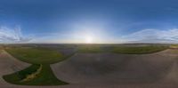 a panoramic view of the sun setting over an empty bowl filled with water