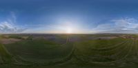 a view of the sunset from a fish eye lens camera pointed at the landscape and the sun