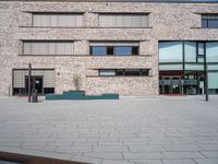 a brick building with windows and large pots on the ground in front of it for privacy