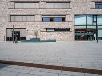 a brick building with windows and large pots on the ground in front of it for privacy