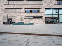 a brick building with windows and large pots on the ground in front of it for privacy