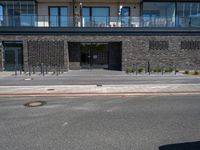 people walking outside of a large building with stone and glass on top of the roof