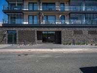 people walking outside of a large building with stone and glass on top of the roof