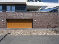 a brick and metal garage that has two doors open to allow people to sit inside