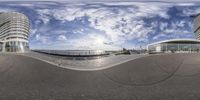 the fisheye lens is positioned on a large circular object in the foreground and a few building