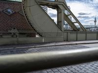 an old road on the side of the street in front of a bridge that stretches into a harbor