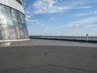 a skateboard is sitting on the asphalt at the top of the building looking into the water