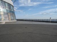 a skateboard is sitting on the asphalt at the top of the building looking into the water