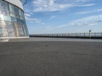 a skateboard is sitting on the asphalt at the top of the building looking into the water