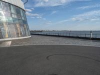 a skateboard is sitting on the asphalt at the top of the building looking into the water