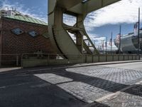 a bridge that crosses over the side of the road to access to a large boat in the distance