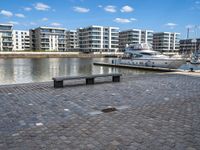 a boat docked at the port next to a bench in a harbor with a cloudy sky